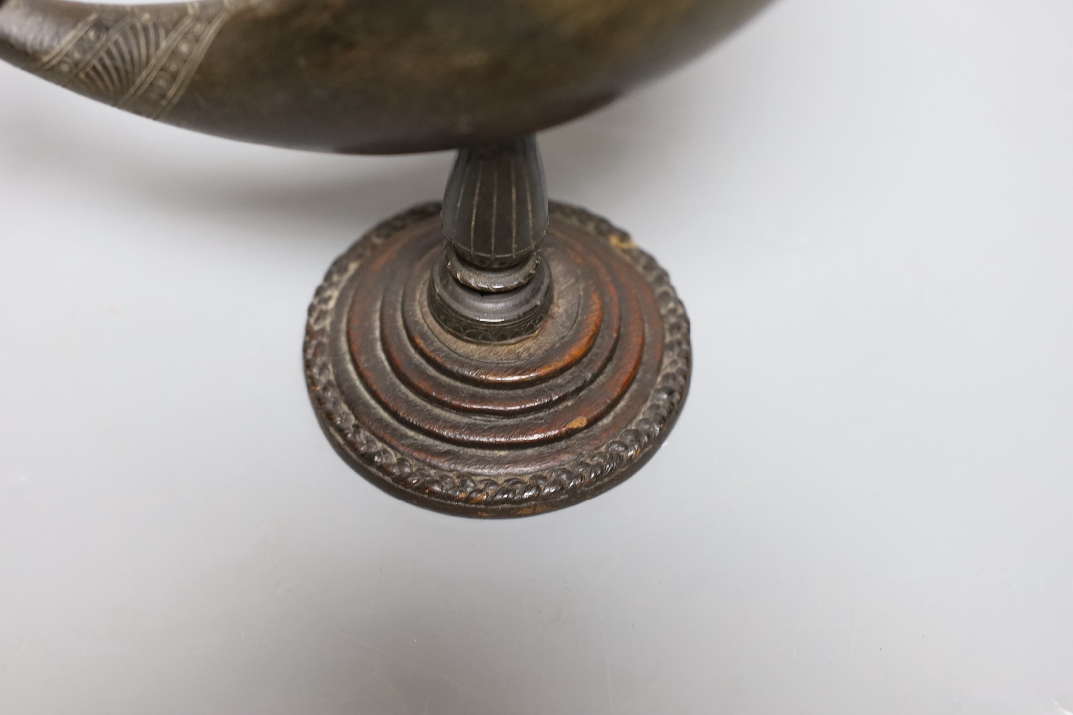 A Persian horn rhyton, 19th century or earlier, with horn stem and stepped wood base, 21cms high, 20.5cm long